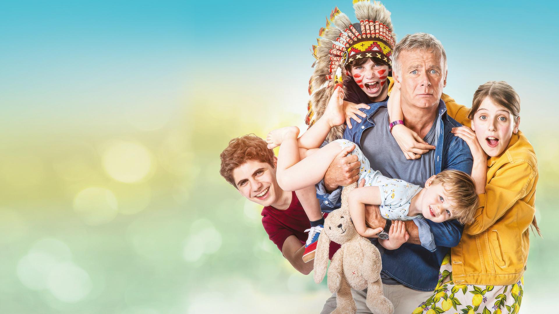 Antoine (Franck Dubosc) blickt mit verängstigtem Gesichtsausdruck nach vorne. An und auf ihm klammern sich die Kinder