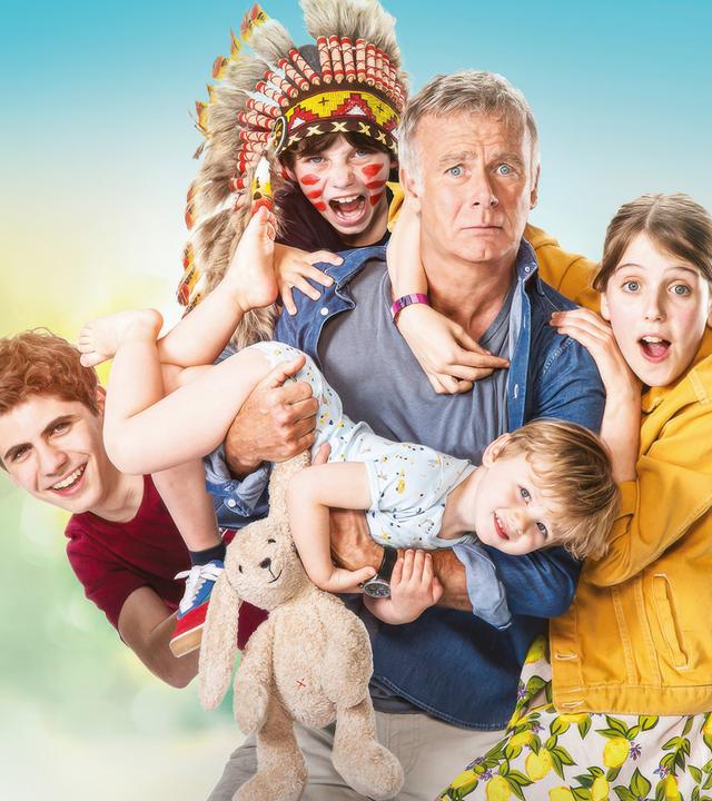 Antoine (Franck Dubosc) blickt mit verängstigtem Gesichtsausdruck nach vorne. An und auf ihm klammern sich die Kinder