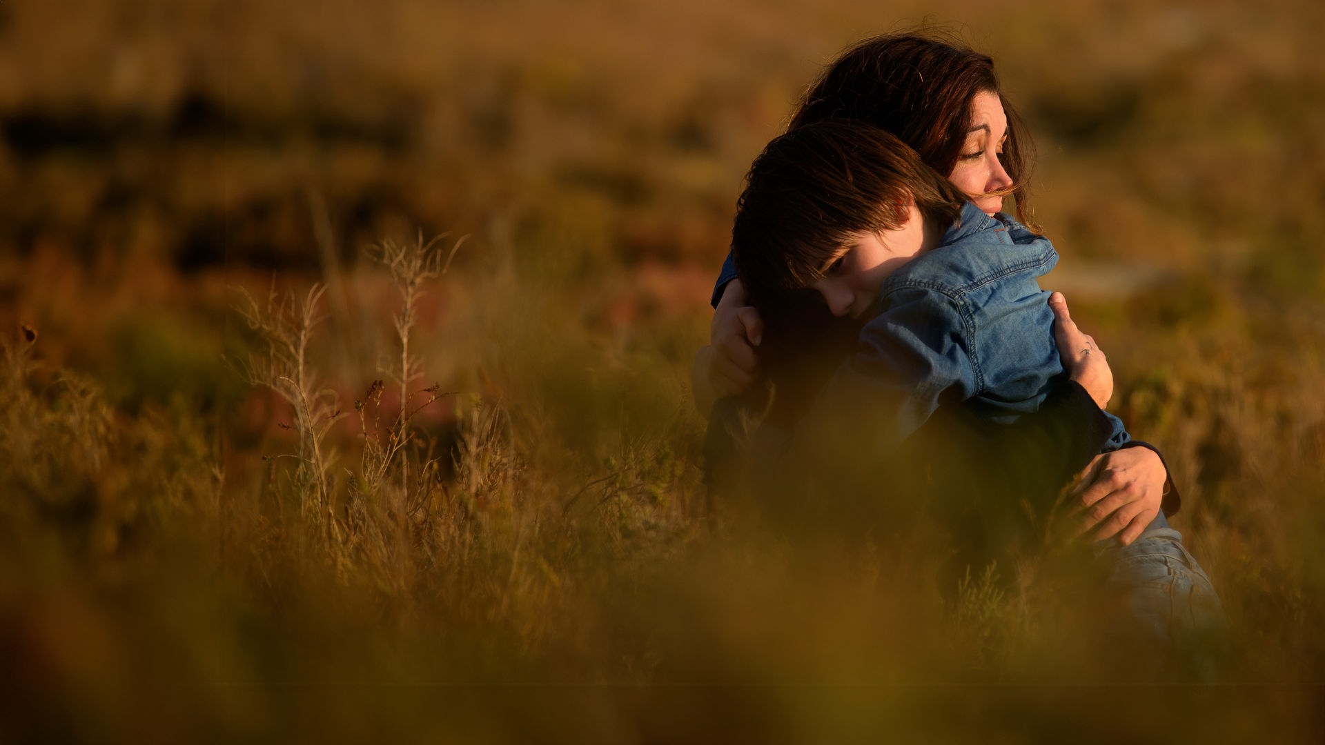 Sarah (Jenifer Bartoli) und Léo (Félix Bossuet) befinden sich auf einer Wiese. Sie umarmen sich.