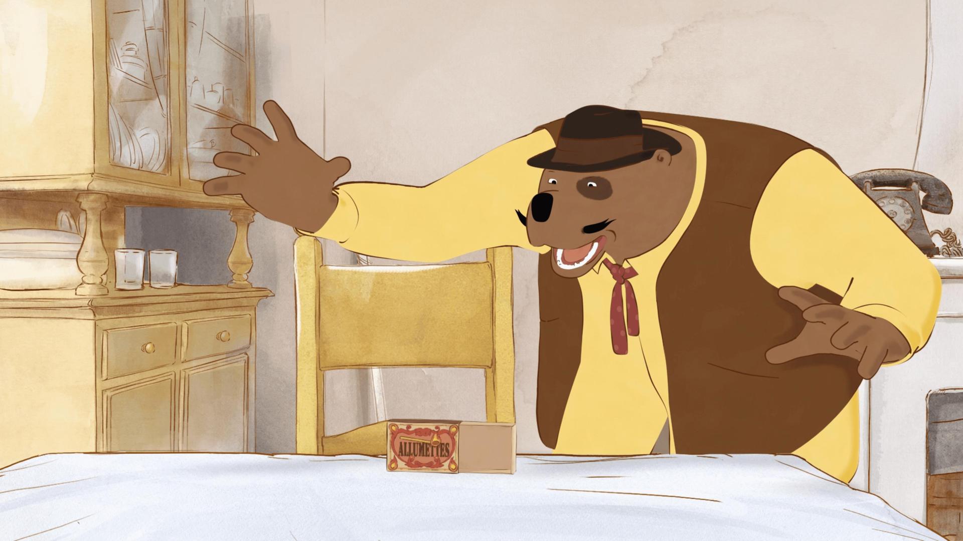 In der Küche auf dem Küchentisch steht eine kleine Streichholzschachtel, die geöffnet ist. Musiker Leon hält seine beiden Arme ausgebreitet und blickt aufgeregt zur Schachtel.