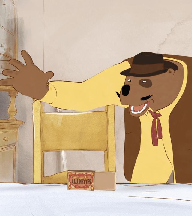 In der Küche auf dem Küchentisch steht eine kleine Streichholzschachtel, die geöffnet ist. Musiker Leon hält seine beiden Arme ausgebreitet und blickt aufgeregt zur Schachtel.