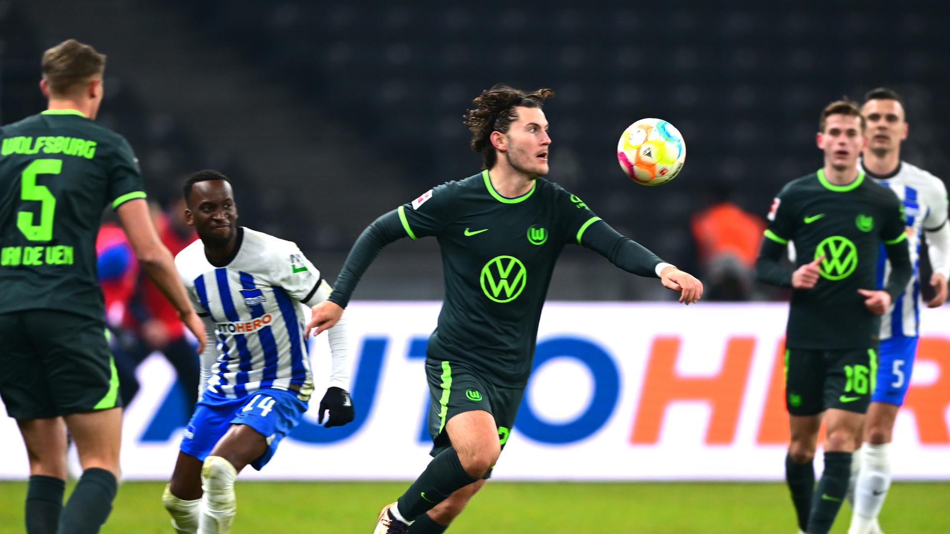 Wolfsburgs Jonas Wind (M) nimmt den Ball vor Herthas Dodi Lukebakio.