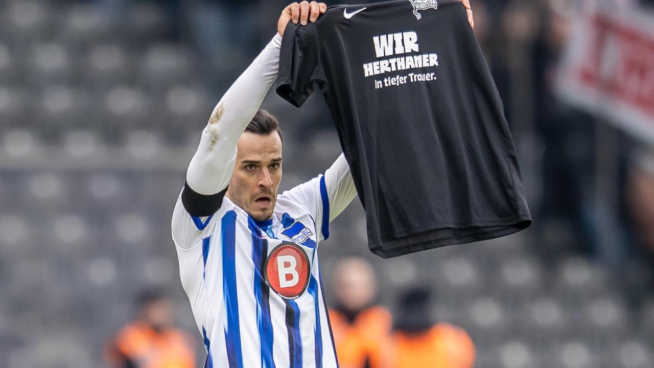 Berlins Haris Tabakovic hält am 21.01.2024 ein schwarzes T-Shirt mit Schriftzug: Wir Herthaner in tiefer Trauer. 