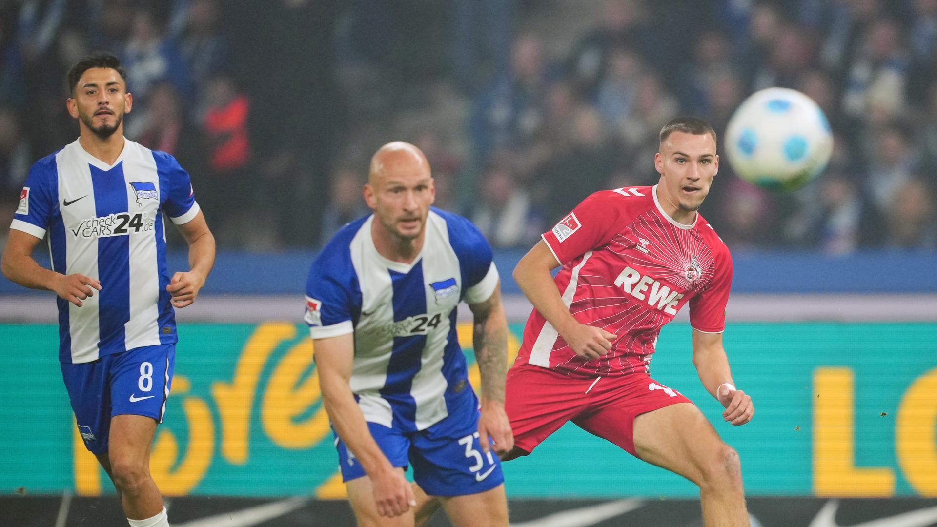 Tim Lemperle (r) schießt vor Herthas Spielern Toni Leistner (M) und Kevin Sessa auf das Tor.