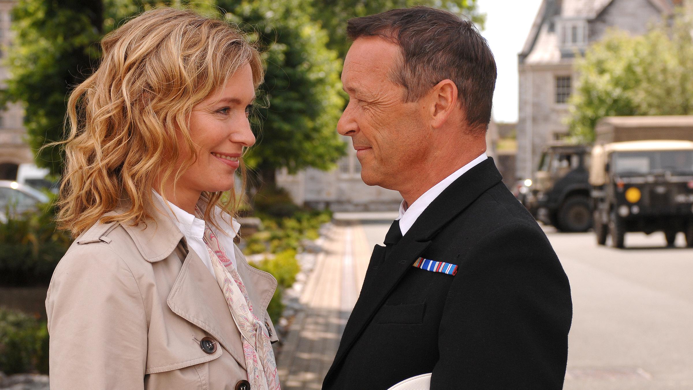 Lady Nicole Sherberton (Katja Weitzenböck) und Duncan Fraser (Michael Roll) stehen sich auf einer Straße gegenüber. Sie lächeln und blicken sich in die Augen.