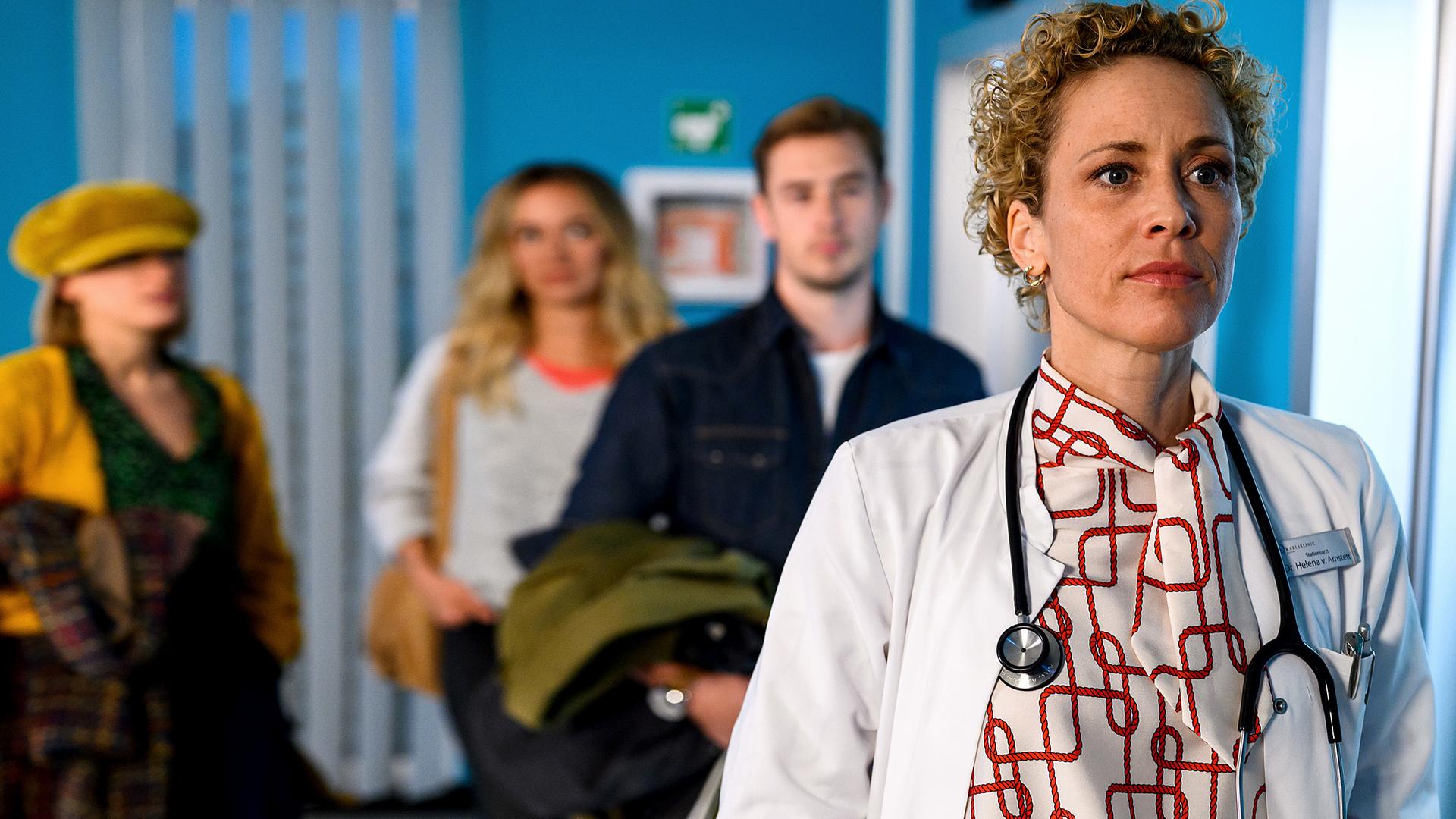 Rike (Isabell Horn), Betty (Annina Hellenthal) und Lukas (Niklas Löffler) stehen auf dem Krankenhausflur und schauen Dr. Helena von Arnstett (Claudia Hiersche) hinterher.