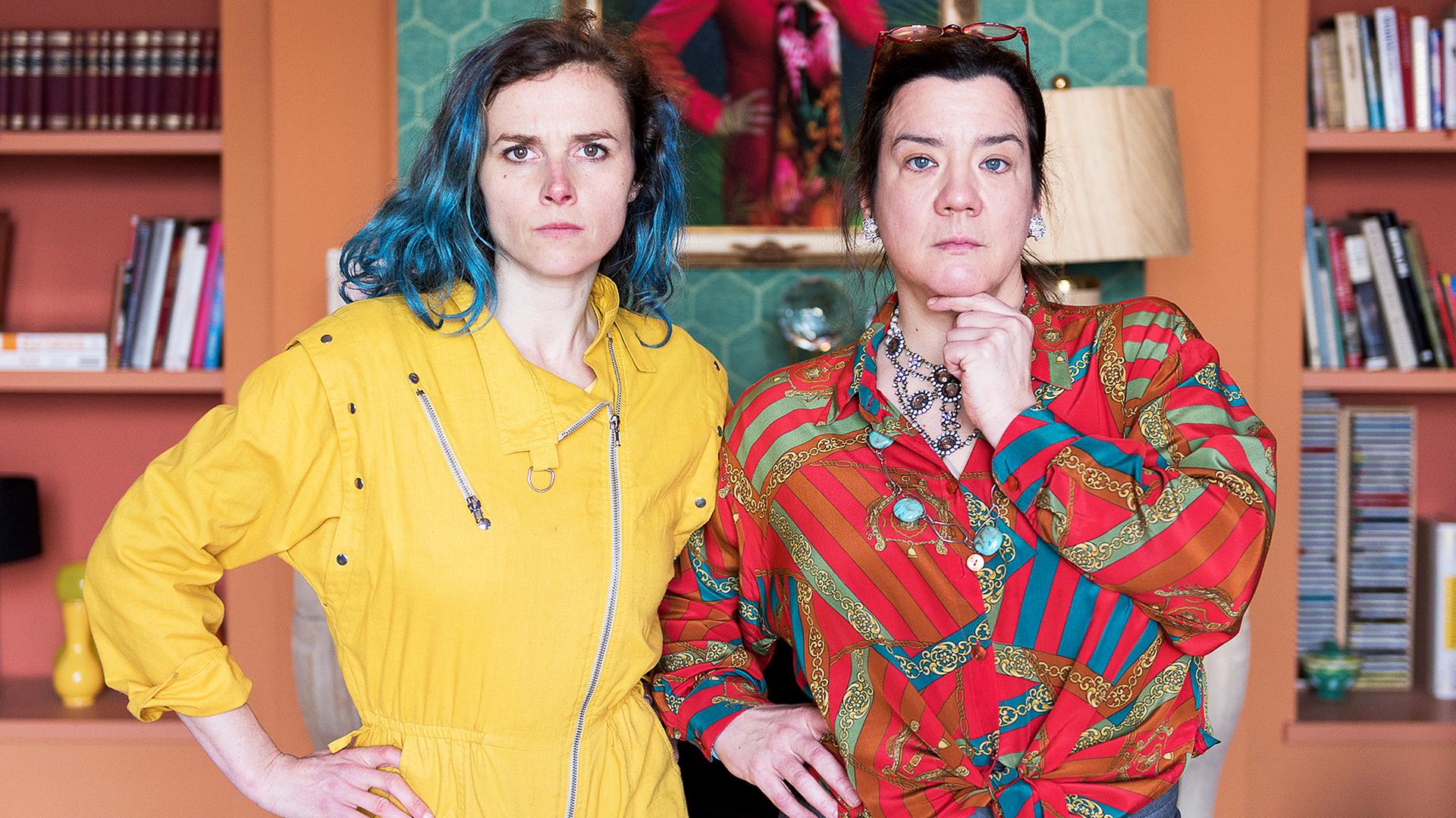 Lin (Karin Hanczewski) und Gloria (Bärbel Schwarz) stehen vor dem Portrait der echten Therapeutin (Belinde Ruth Stieve).