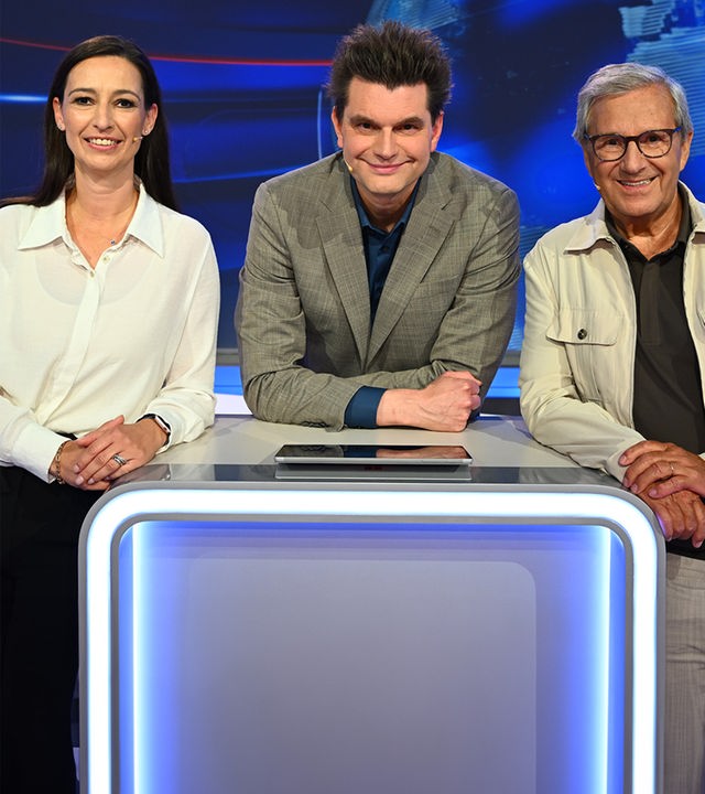 Lutz van der Horst steht im Studio hinter einem Pult. Links von ihm befindet sich Pinar Atalay und rechts von ihm Jan Hofer.