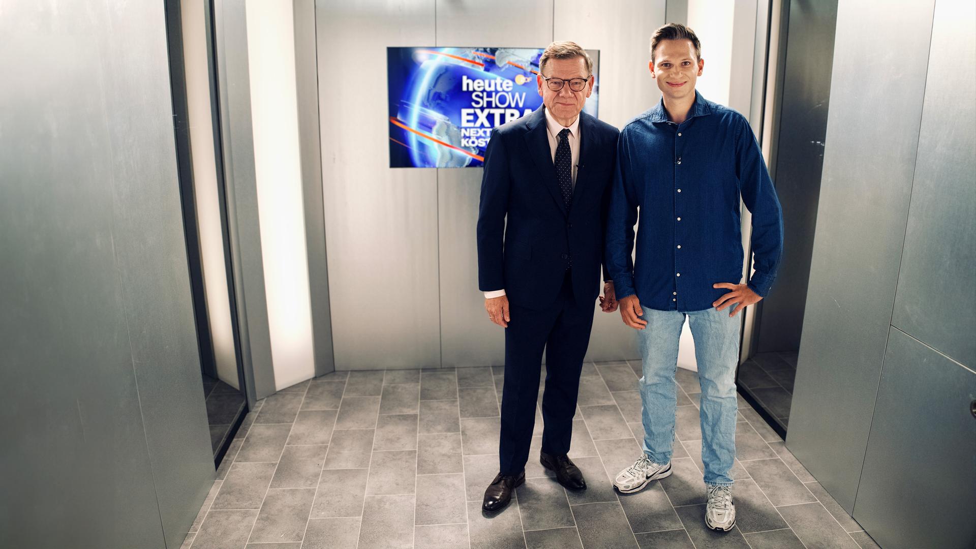 Fabian Köster und Johann Wadephul stehen im Aufzug und schauen freundlich in die Kamera.