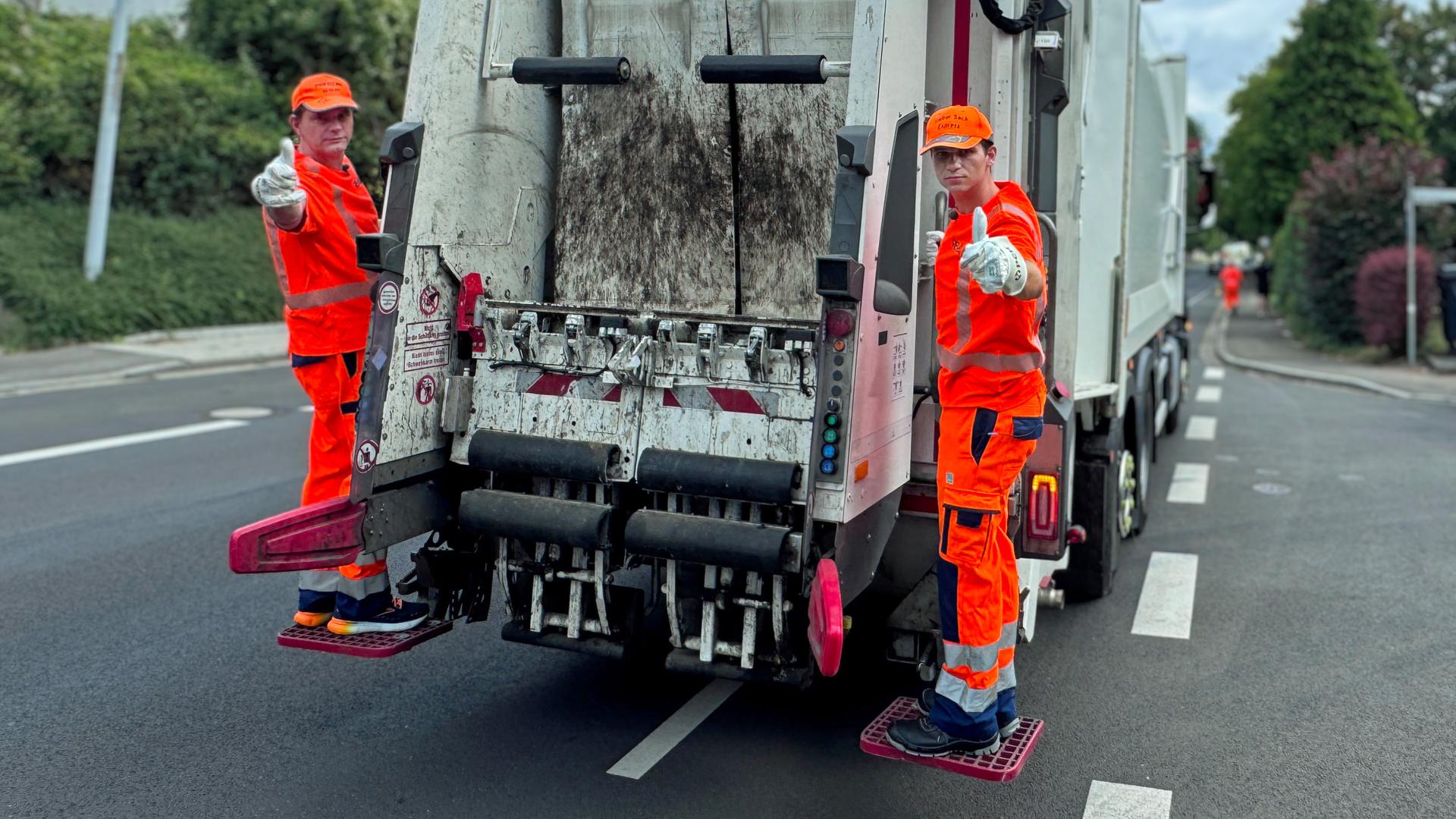 Lutz van der Horst und Fabian Köster im Einsatz bei der Müllabfuhr.