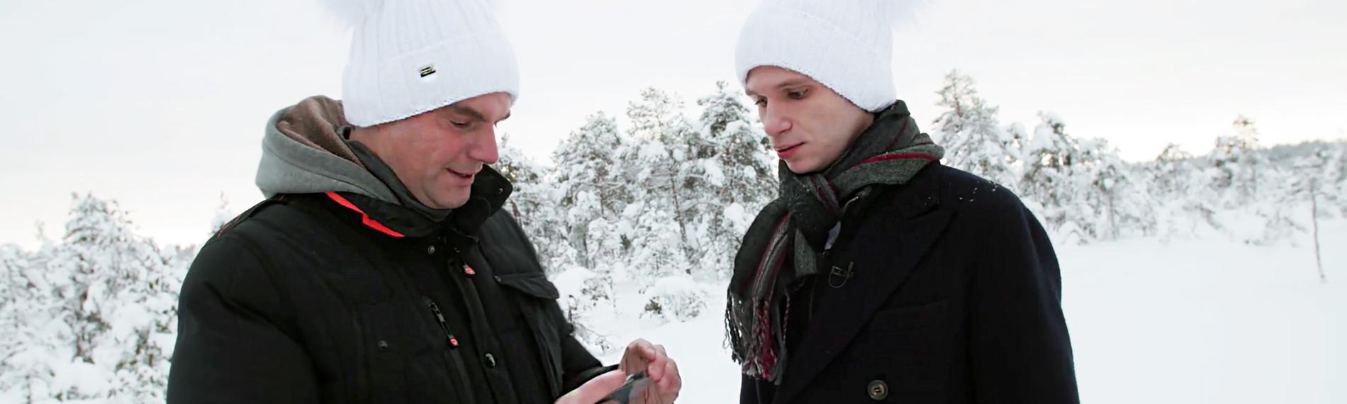 "heute-show spezial - Deutschland hat das Faxen dicke": Lutz van der Horst und Fabian Köster stehen nebeneinander am Rande eines Waldes im winterlichen Estland. Beide schauen auf das Mobiltelefon von Lutz van der Horst.