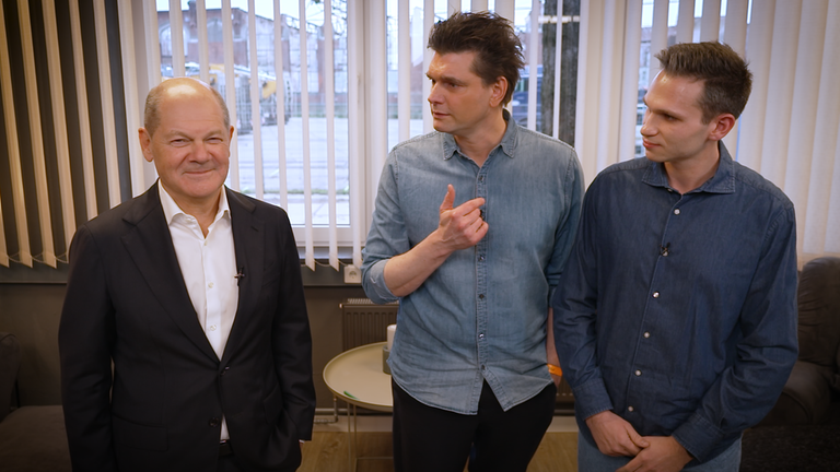 Die heute-show-Reporter Fabian Köster und Lutz van der Horst stehen neben Bundeskanzler Olaf Scholz