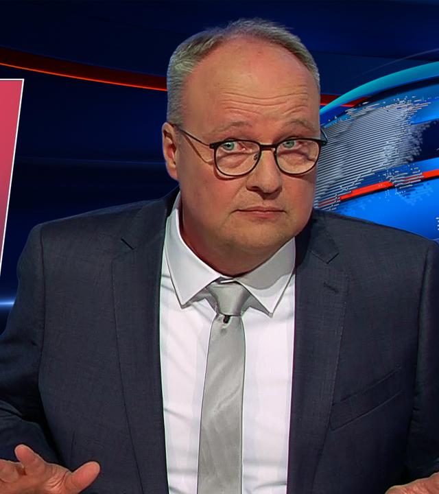 Oliver Welke sitzt am Schreibtisch. Links neben ihm ist ein Buch abgebildet. Auf dem Cover ist ein Porträt von Donald Trump zu sehen. Der Titel des Buchs lautet "Verhandeln nach der Trump Methode".