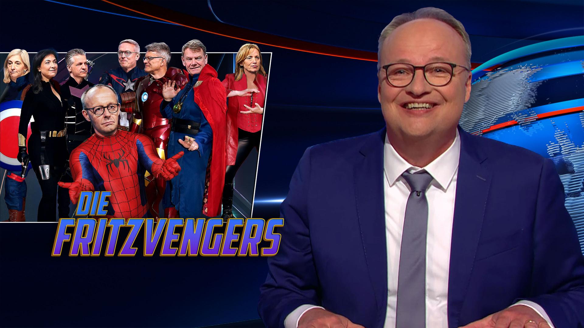 Oliver Welke sitzt am Schreibtisch. Links neben ihm sind Friedrich Merz und seine designierten Ministerinnen und Minister in digital gestalteten Superheldenkostümen abgebildet. Im Bild steht die Schrift "Die Fritzvengers".