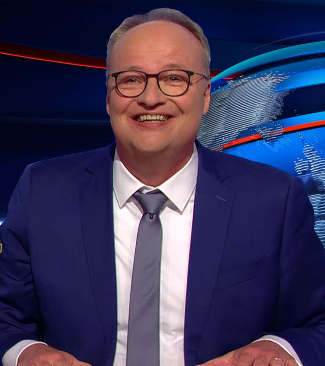 Oliver Welke sitzt am Schreibtisch. Links neben ihm sind Friedrich Merz und seine designierten Ministerinnen und Minister in digital gestalteten Superheldenkostümen abgebildet. Im Bild steht die Schrift "Die Fritzvengers".