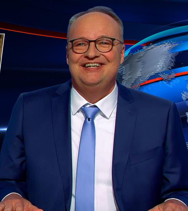 Oliver Welke sitzt rechts im Bild. Links im Bild ist eine satirische Fotocollage von zwei älteren Personen in einem Hühnerstall zu sehen. Darunter steht: "Meine Oma pflegt im Hühnerstall den Opa".