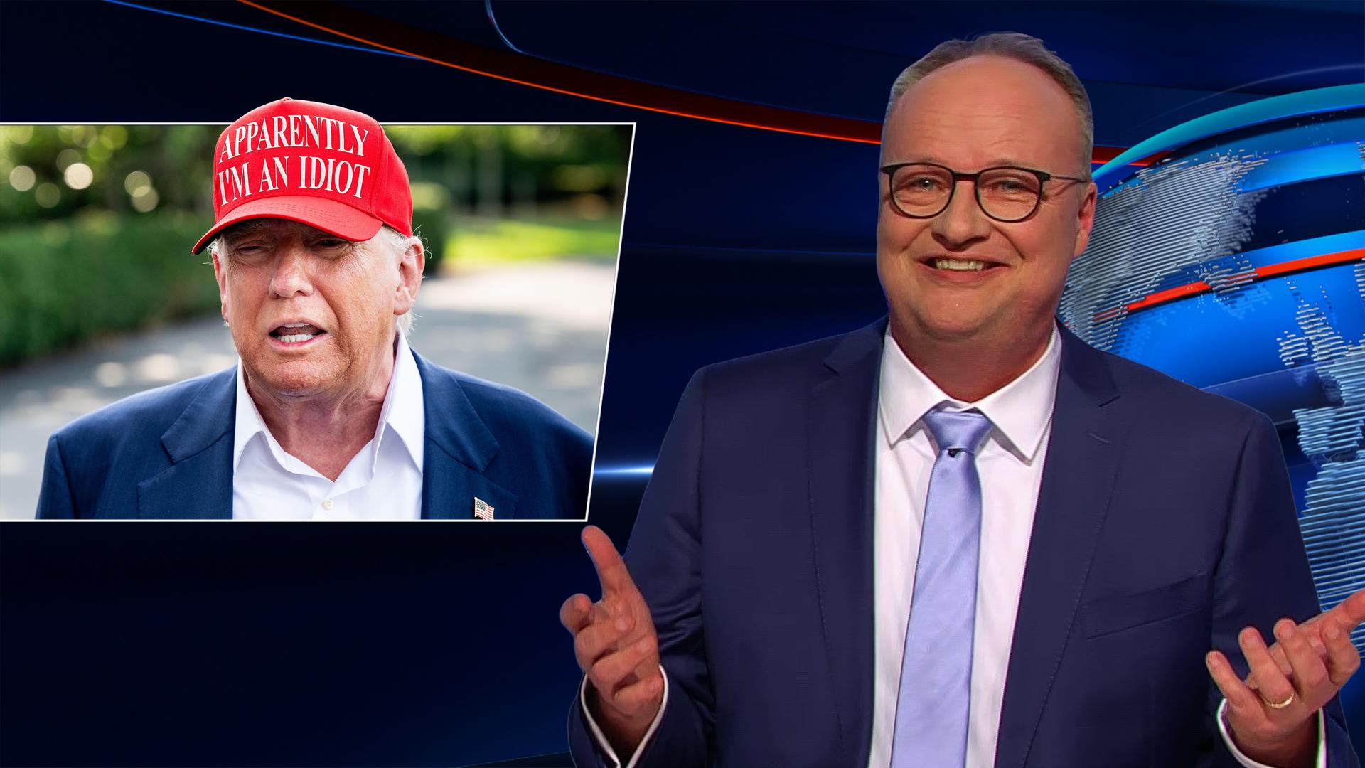 Oliver Welke sitzt am Schreibtisch. Links neben ihm ist eine Fotomontage von Donald Trump abgebildet. Trump trägt eine rote Baseballkappe, auf der steht: "APPARENTLY I’M AN IDIOT".