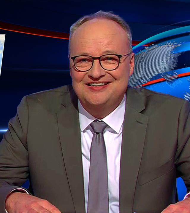 Oliver Welke sitzt am Schreibtisch. Links neben ihm ist eine Fotomontage im Stil der ikonischen Szene aus "Der König der Löwen" zu sehen: Angela Merkel steht auf einem Felsen und hält ein Baby mit dem Gesicht von Friedrich Merz hoch. Am unteren Bildrand steht: "The Merkel of Life".