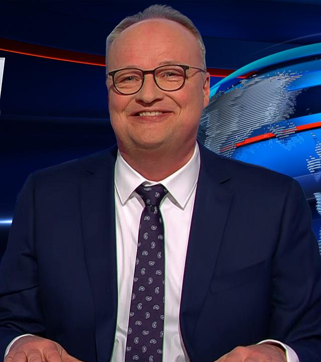 Oliver Welke sitzt am Schreibtisch. Links im Hintergrund ist eine Fotomontage abgebildet, die an den Animationsfilm "Ich – Einfach unverbesserlich" erinnert: Darauf steht Friedrich Merz neben drei Minions. Darunter steht: "Ich – Einfach unbeliebt".