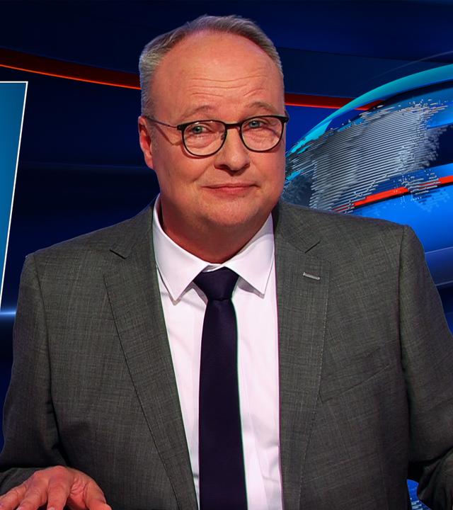 Oliver Welke sitzt am Schreibtisch. Links von ihm ist ein Baby in einem Hochstuhl zu sehen, auf das das Gesicht von Friedrich Merz montiert ist. Darunter steht: Ich will aber Stadtbild sagen!