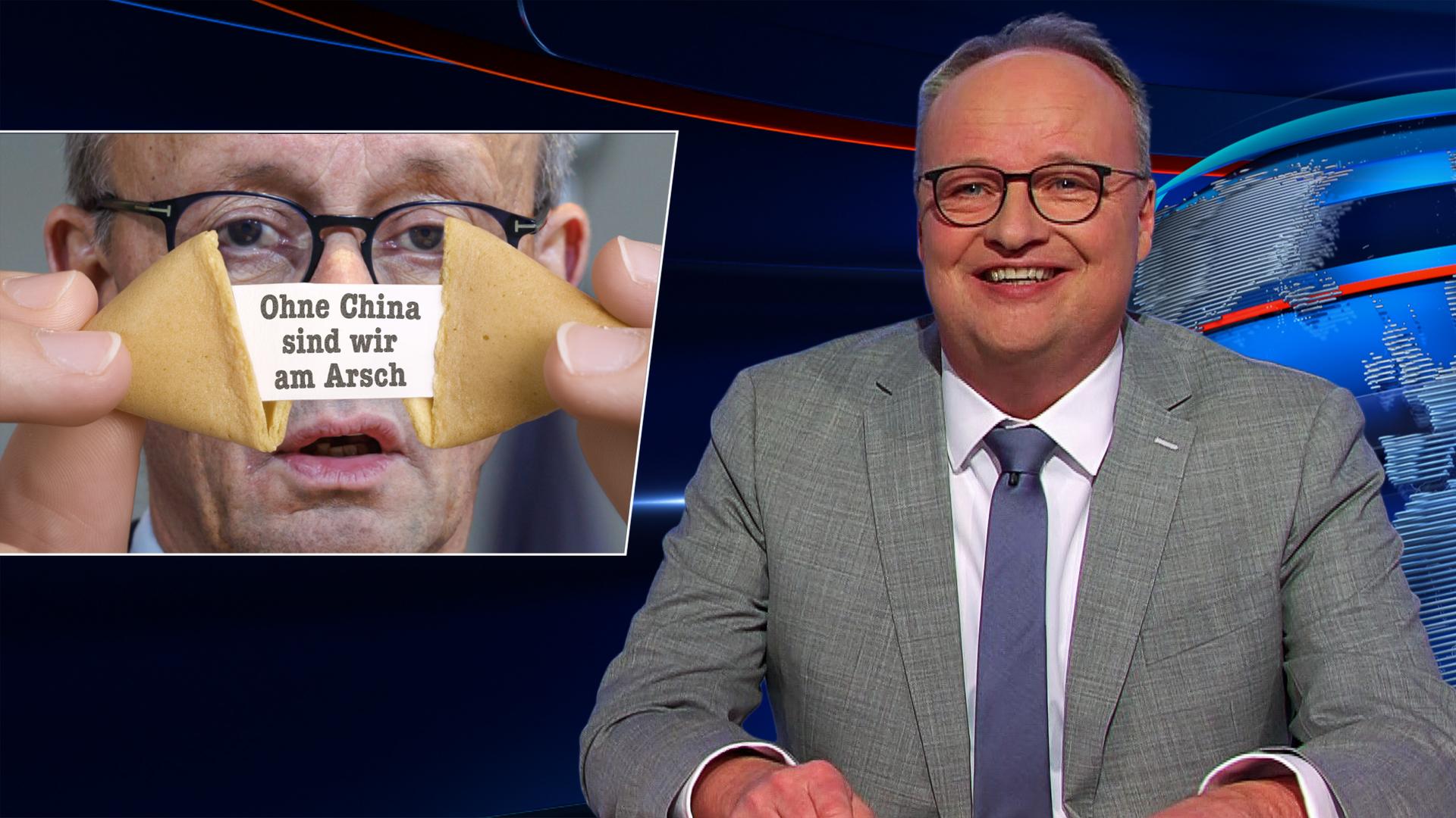 Oliver Welke sitzt am Schreibtisch. Links von ihm ist eine Fotomontage von Friedrich Merz zu sehen, der einen Glückskeks öffnet. Darin befindet sich ein Zettel mit dem Spruch: "Ohne China sind wir am Arsch".
