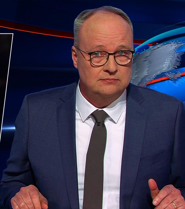 Oliver Welke sitzt am Schreibtisch. Links von ihm ist eine Fotomontage von Donald Trump zu sehen, der hinter einem Rednerpult steht und eine goldene Medaille hochhält. Darunter steht: "Endlich Kriegsnobelpreis".