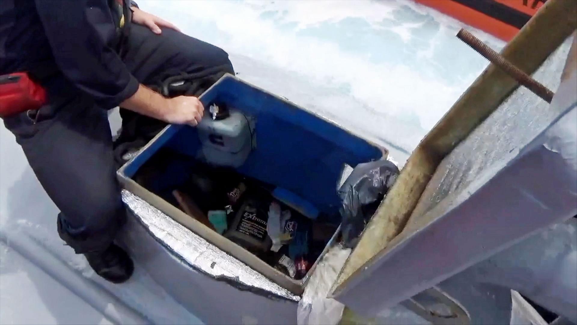 "Hightech-Gangster - Kokain per U-Boot und ein Kasino-Raub": Mann von der US-Küstenwache sitzt auf einem Mini-U-Boot und schaut durch die geöffnete Luke in das Innere.