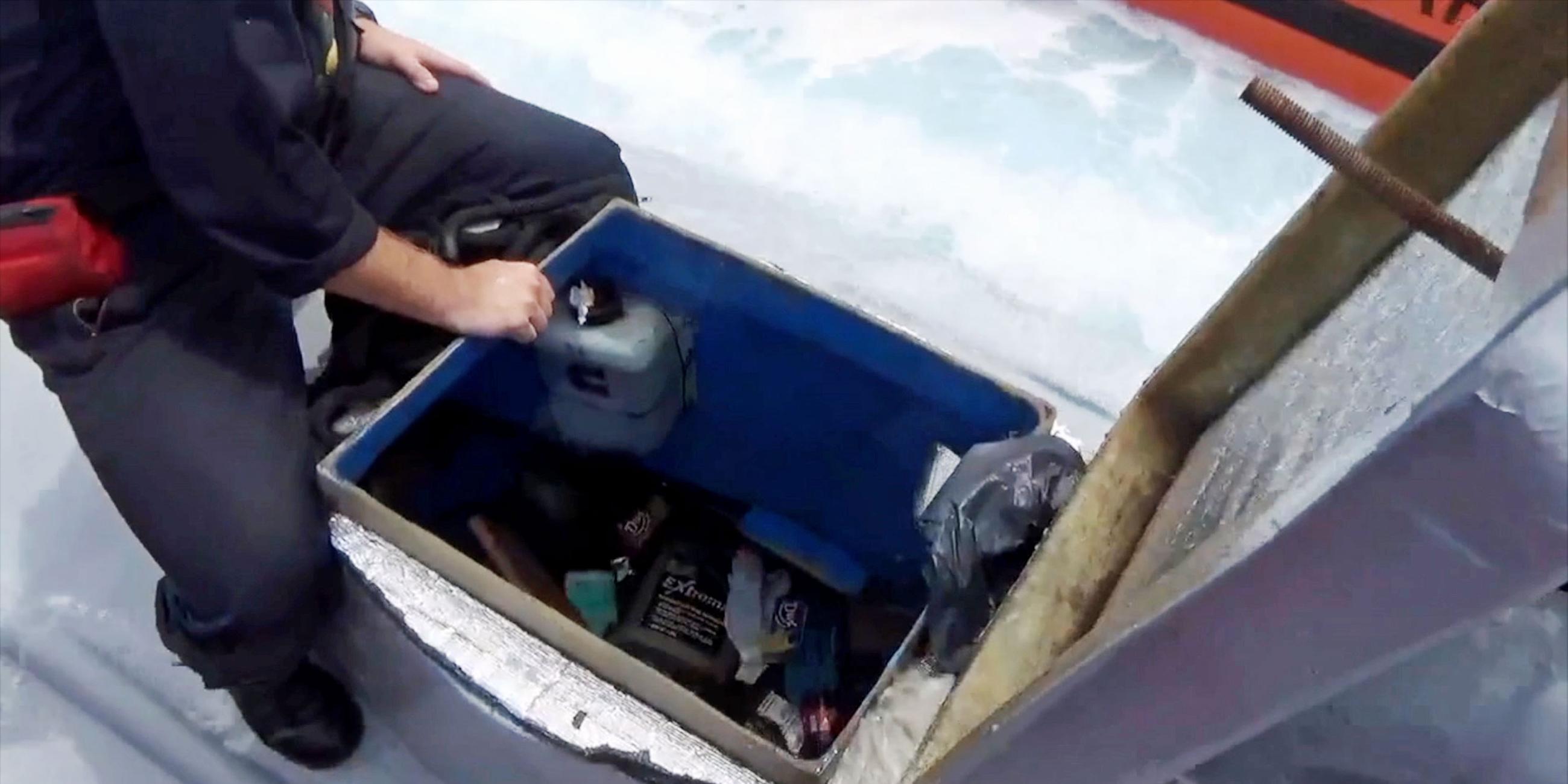 "Hightech-Gangster - Kokain per U-Boot und ein Kasino-Raub": Mann von der US-Küstenwache sitzt auf einem Mini-U-Boot und schaut durch die geöffnete Luke in das Innere.