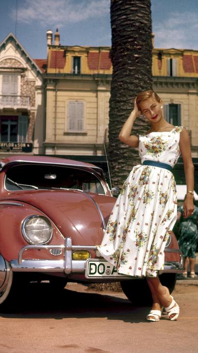 "History Deutschland - Meilensteine und Mythen: Der Westen ": Eine Frau steht vor einem roten Auto.