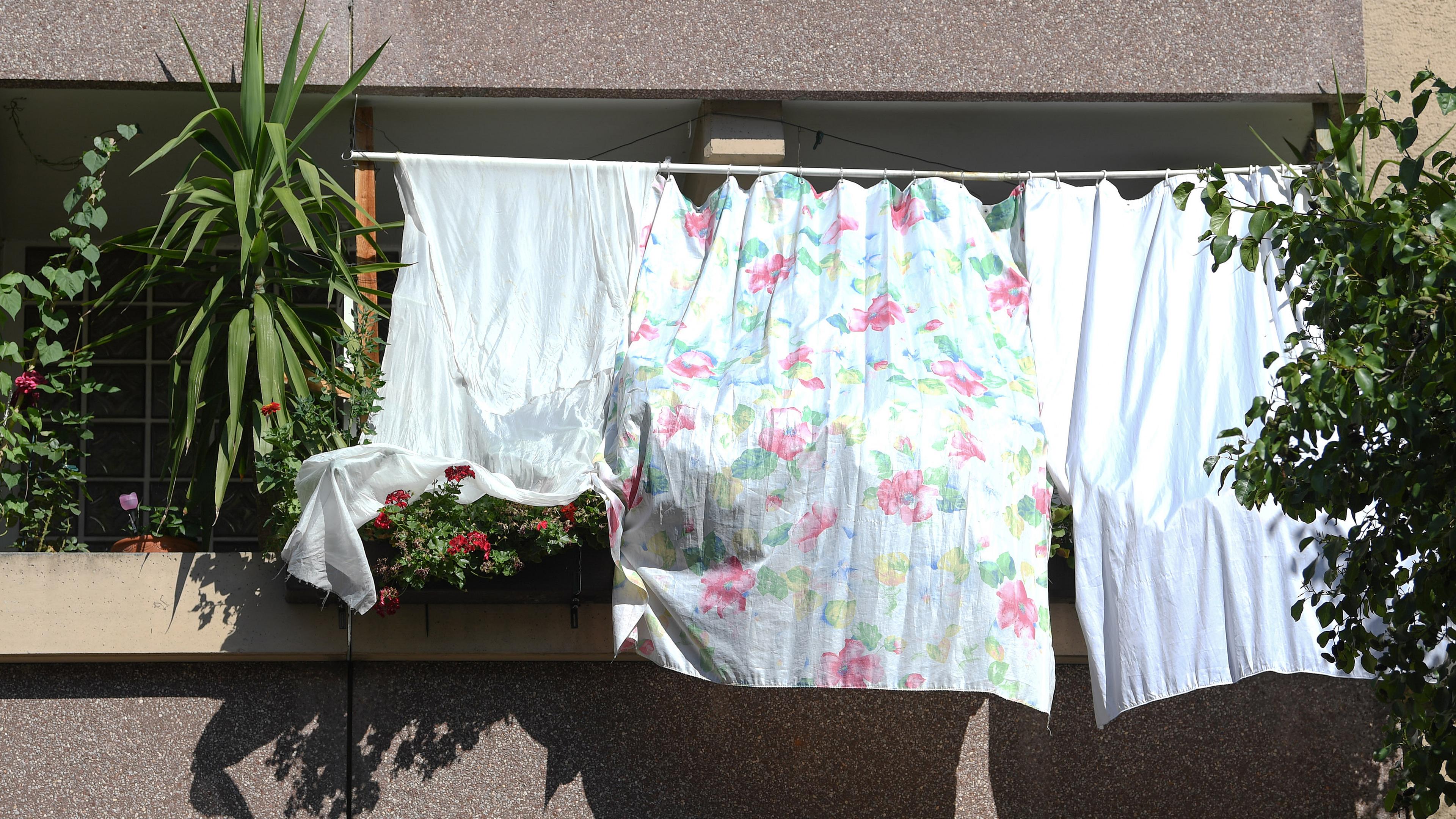 Mit Tüchern schützen Bewohner ihre Wohnung vor der heissen Sonne