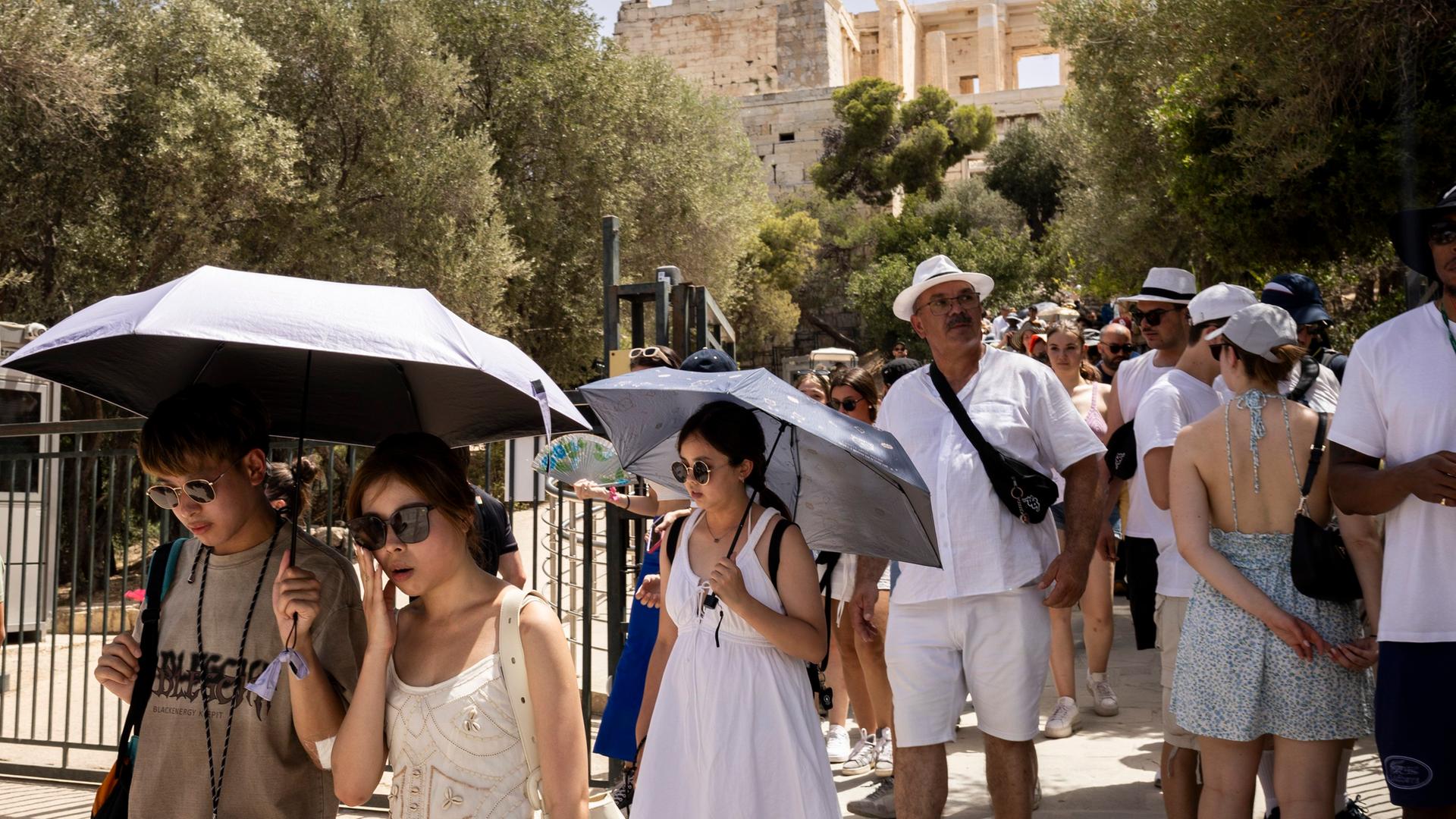 Touristen verlassen die Akropolis, die von 12:00 bis 17:00 Uhr wegen der Hitze geschlossen ist.