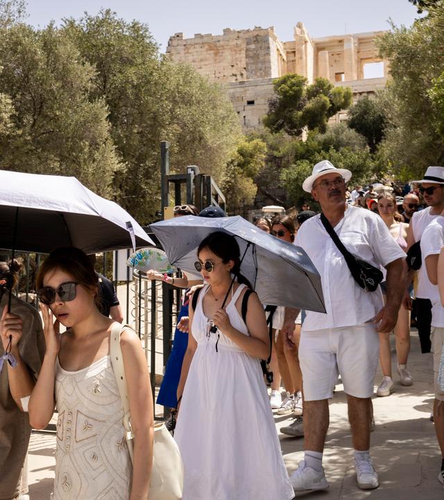 Touristen verlassen die Akropolis, die von 12:00 bis 17:00 Uhr wegen der Hitze geschlossen ist.