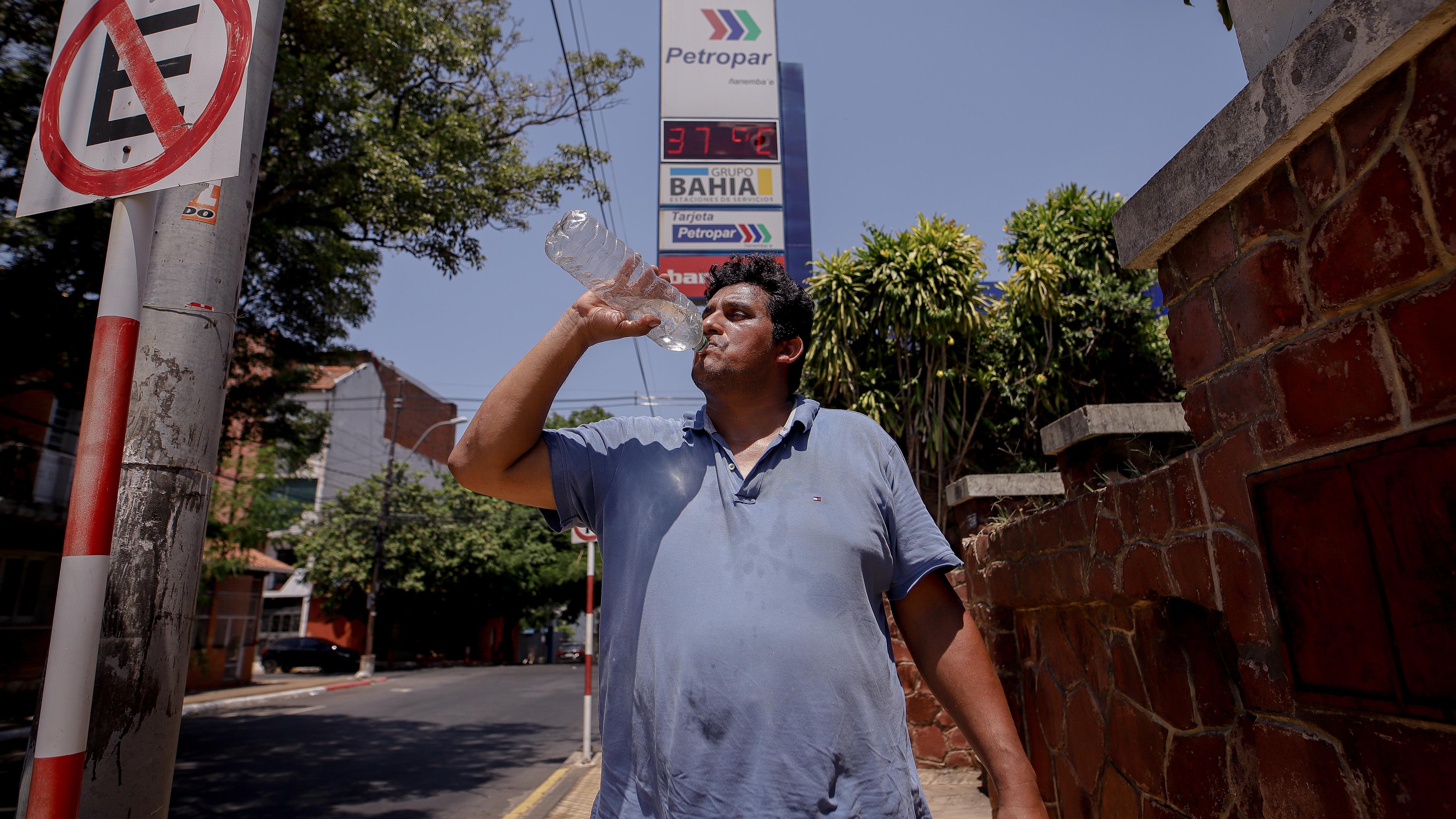 Paraguay, Asuncion: Ein Mann trinkt am Samstag Wasser aus einer Flasche auf einer Straße