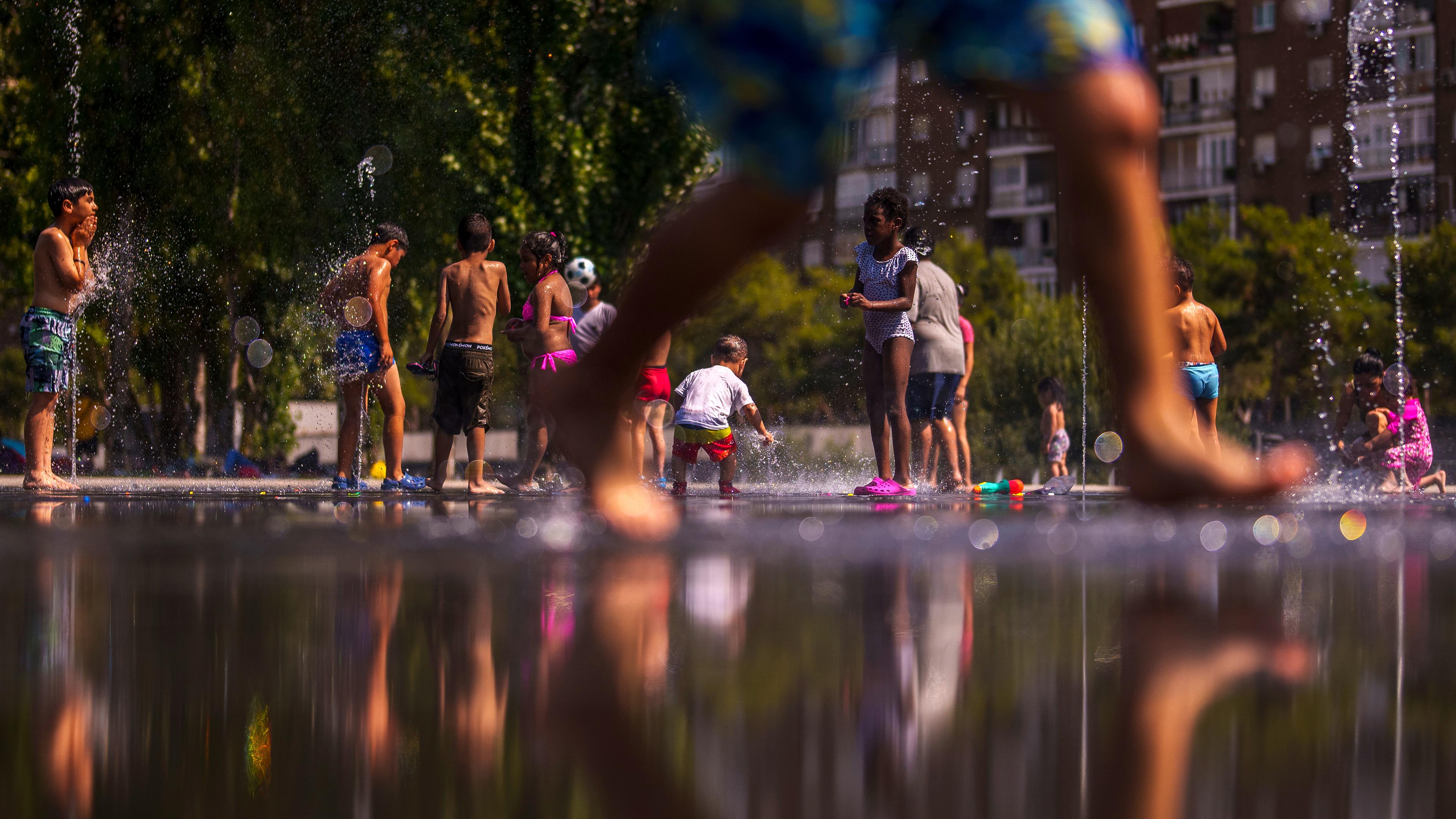 Kinder erfrischen sich an einem städtischen Strand im Madrid Rio Park in Madrid, aufgenommen am 26.06.2023