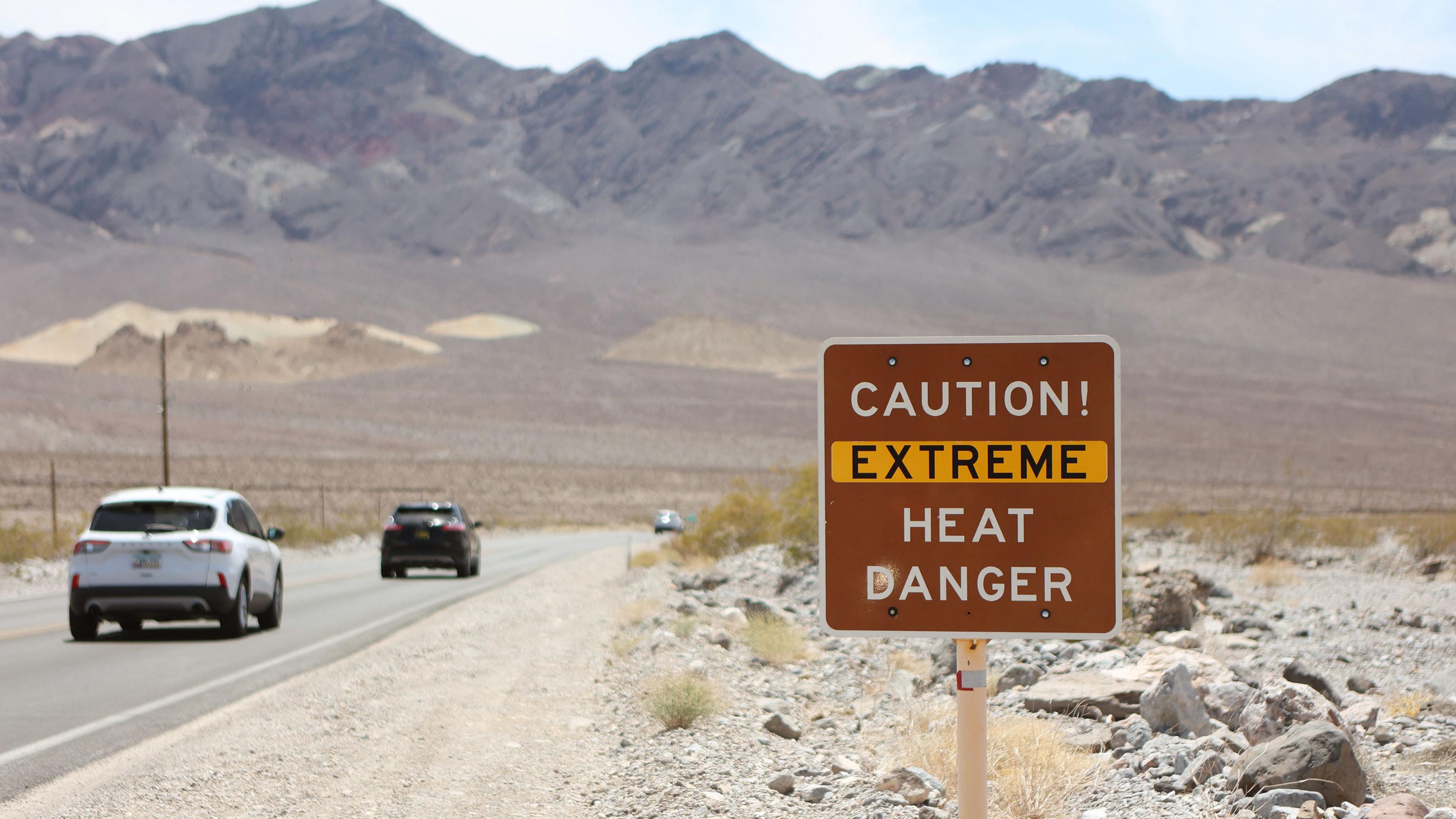 Während einer Hitzewelle im Death Valley National Park im kalifornischen Death Valley ist am US Highway 190 ein Hitzewarnschild zu sehen.