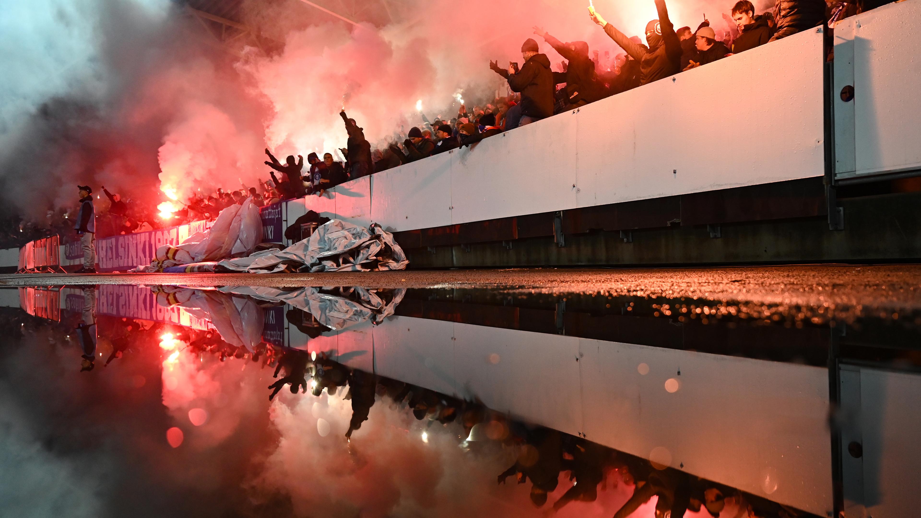 Finnland, Helsinki: Fußball: UEFA Europa Conference League, HJK Helsinki - Eintracht Frankfurt: Helsinkis Fans brennen im Fanblock Feuerwerkskörper ab.