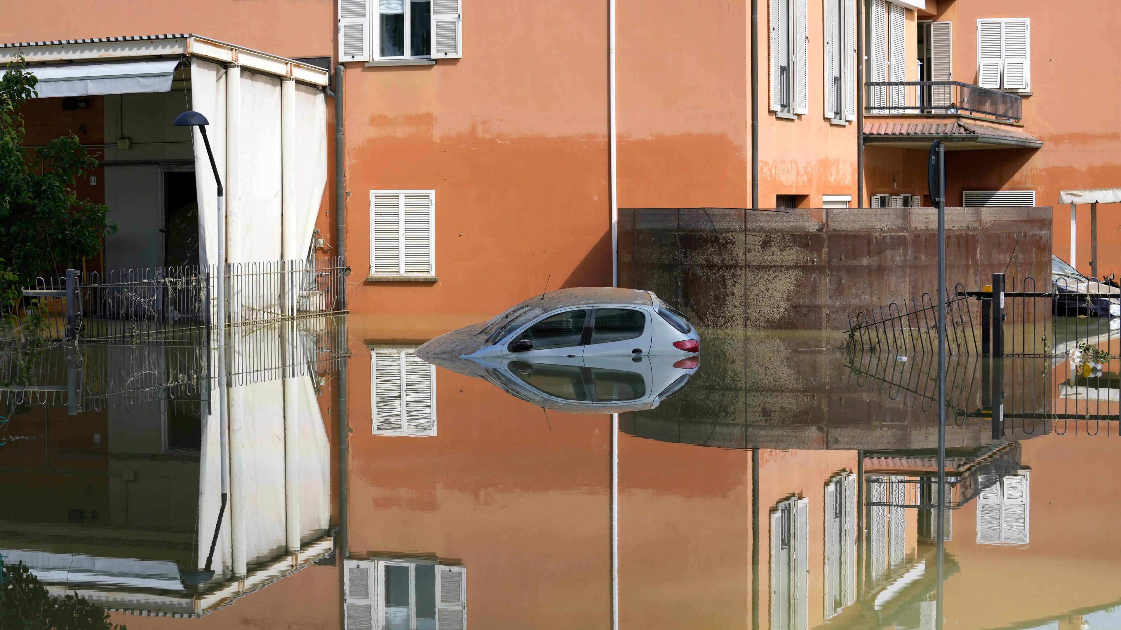 Ein Auto parkt im Hochwasser einer überschwemmten Region.