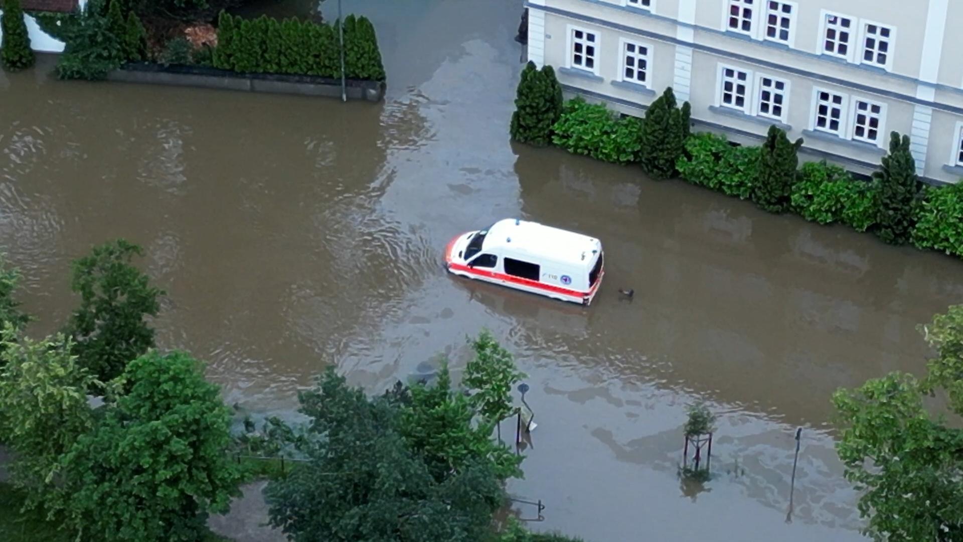 Ein Krankenwagen fährt über eine überschwemmte Straße in Schrobenhausen im Landkreis Neuburg-Schrobenhausen. (Luftaufnahme mit einer Drohne).