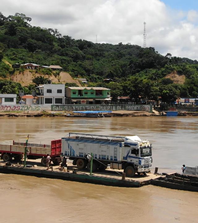 Eine Fähre bringt einen Laster über Gewässer.