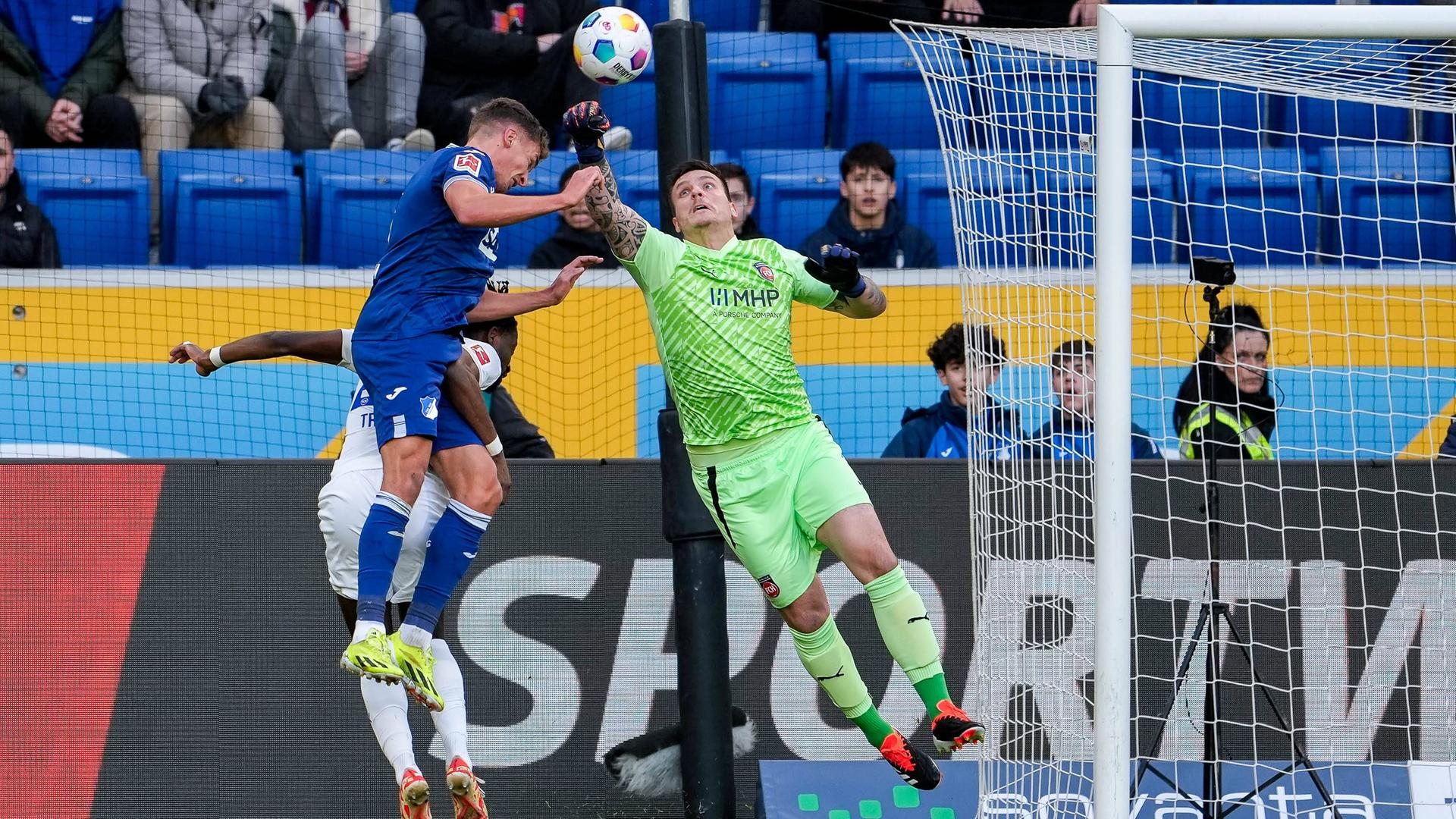 Kopfballduell zwischen Grischa Prömel (Hoffenheim), Omar-Haktab Traore (FC Heidenheim) und dem Torwart Kevin Müller (FC Heidenheim).