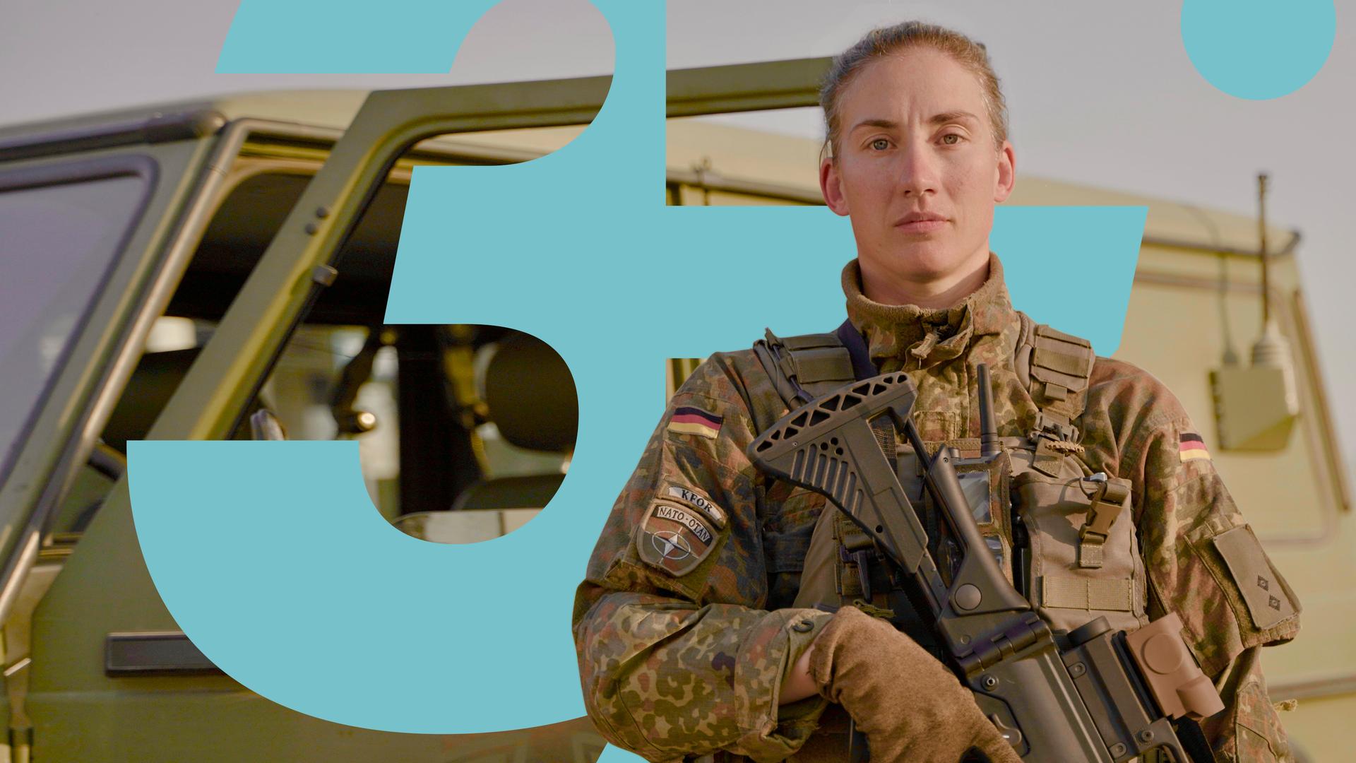 Alina steht in Flecktarn-Uniform und Schutzweste vor einem Bundeswehrauto. Sie hält das Handmikrofon eines Funkgeräts dicht an den Mund und spricht hinein.