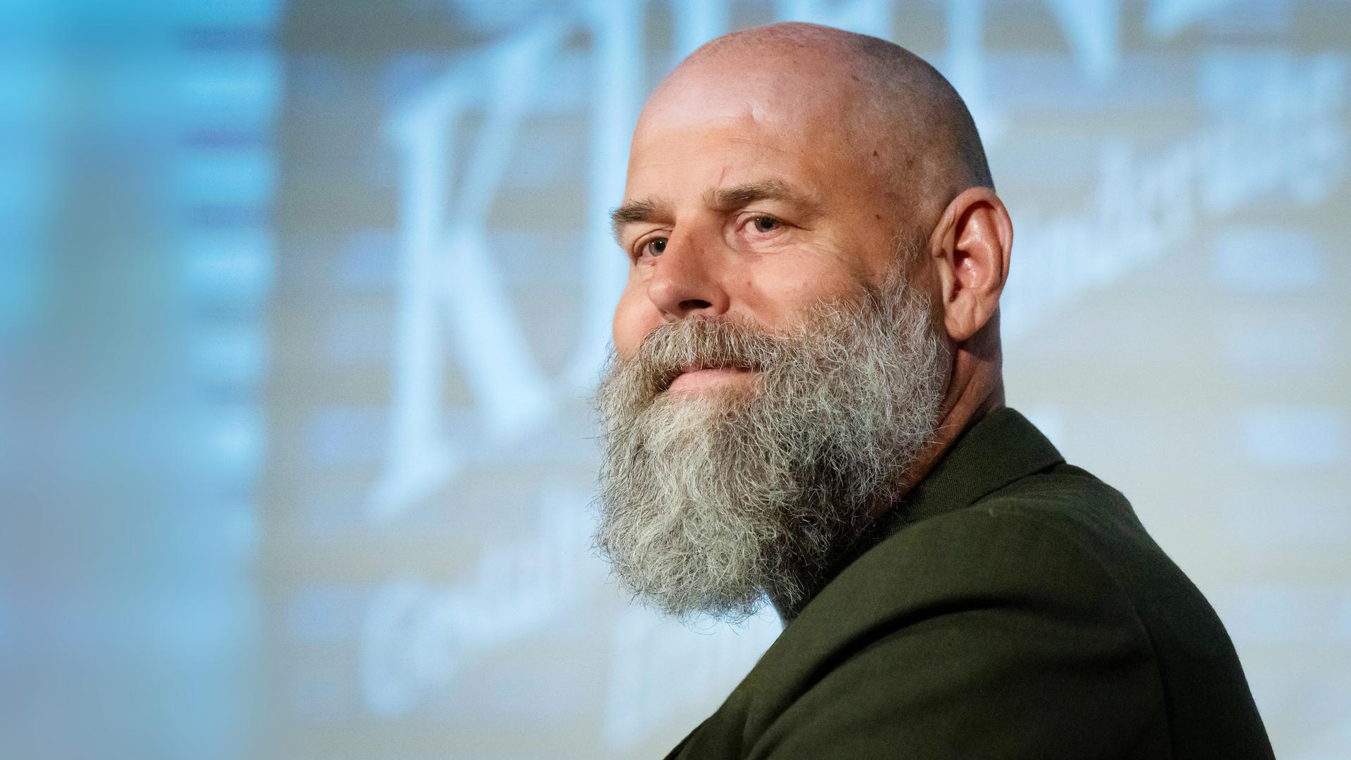 Ein Mann mit Glatze trägt einen Bart.