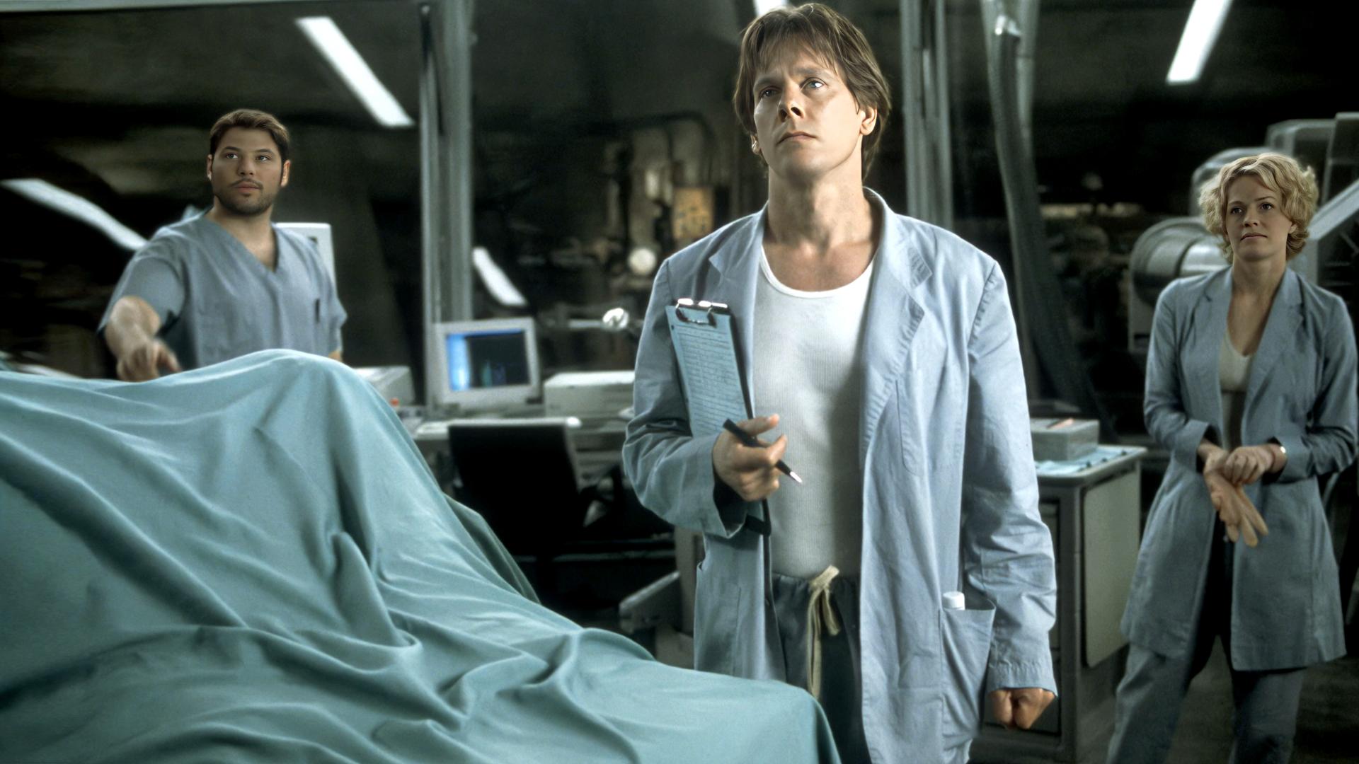  Sebastian Caine (Kevin Bacon), Carter Abbey (Greg Grunberg) und Linda McKay (Elisabeth Shue) stehen in einem Labor und blicken in die Ferne.