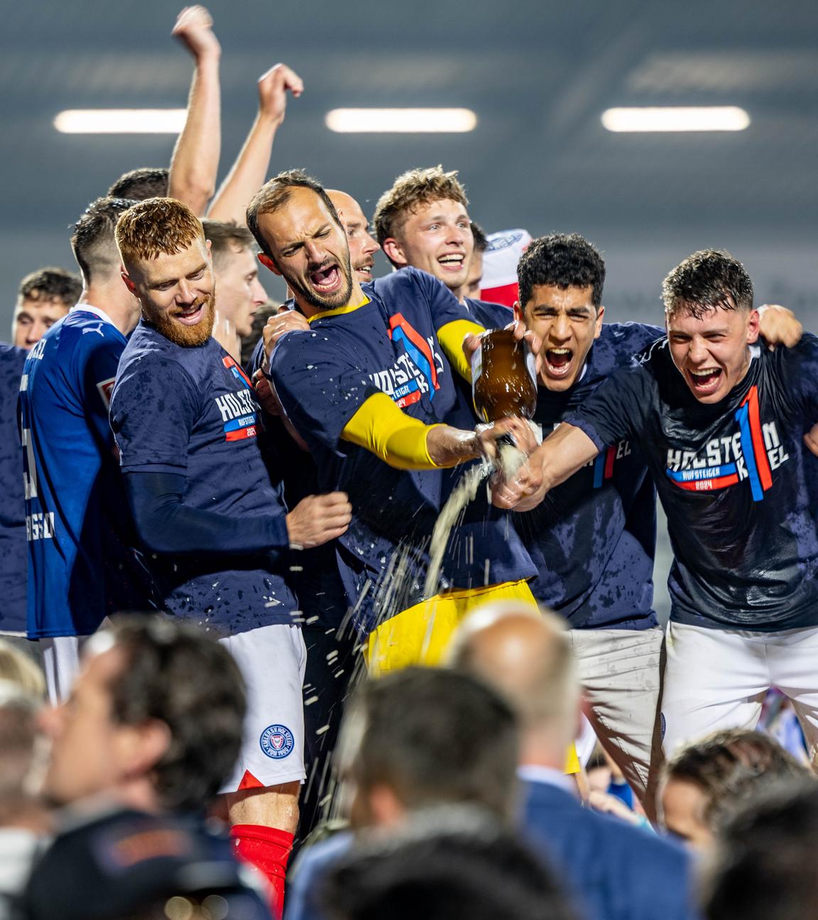 Die Spieler von Holstein Kiel feiern mit den Fans gemeinsam den Aufstieg.