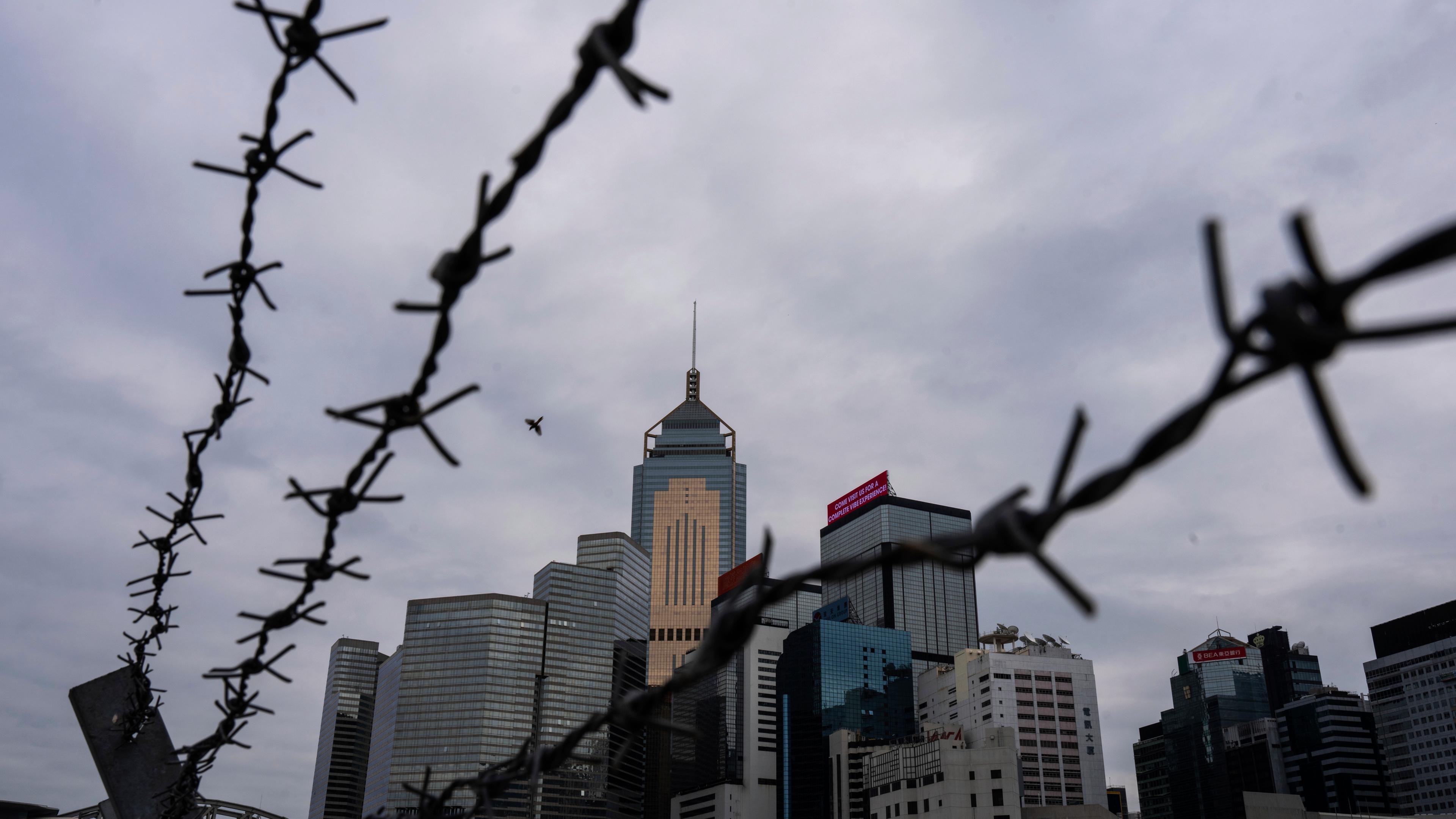 Stacheldraht vor der Skyline von Hongkong.