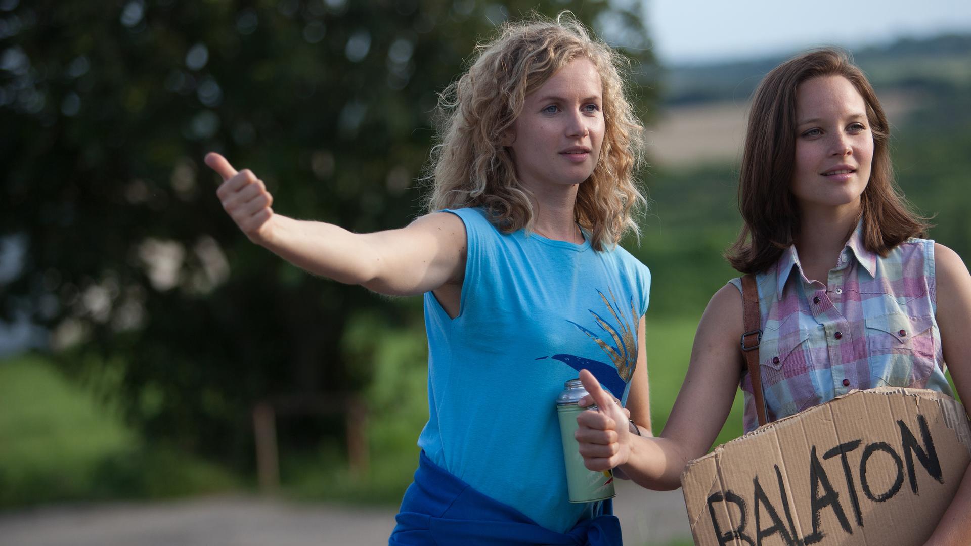Die beiden Schwestern Catrin Streesemann (Cornelia Gröschel, l.) und Maja Streesemann (Sonja Gerhardt, r.) versuchen per Anhalter zum Balaton zu kommen, wo sie ihren gemeinsamen Urlaub verbringen möchten.