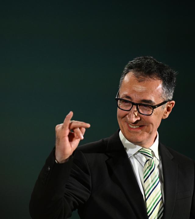 08.03.2026, Baden-Württemberg, Stuttgart: Cem Özdemir (Bündnis 90/Die Grünen), Spitzenkandidat Landtagswahl Baden-Württemberg, macht bei der Wahlparty seiner Partei eine Geste und reckt den kleinen Finger der rechten Hand hoch.