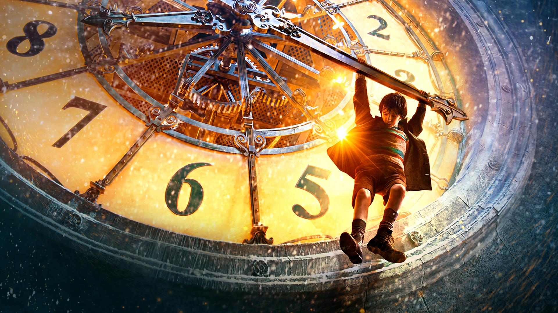 Plakatmotiv zum Film mit Asa Butterfield. Hugo hängt mit beiden Armen am Zeiger der großen Uhr des Pariser Bahnhofs.