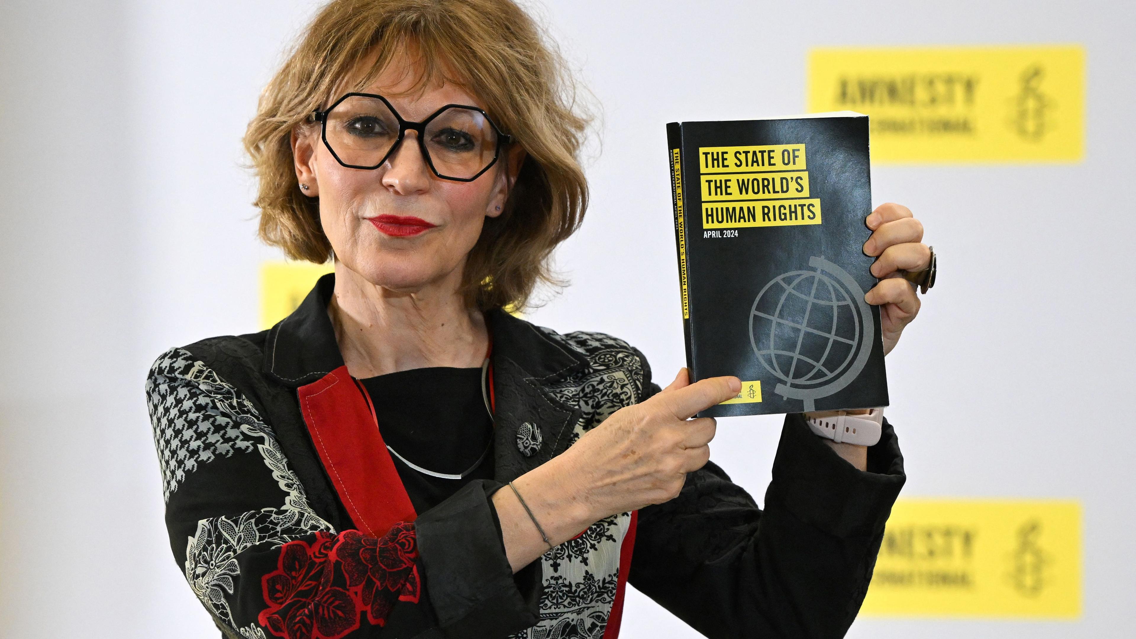 Die französische Menschenrechtsaktivistin und Generalsekretärin von Amnesty International Agnes Callamard zeigt den Menschenrechtsbericht „The State of the World“ von Amnesty International während einer Pressekonferenz am 23. April 2024 in London.