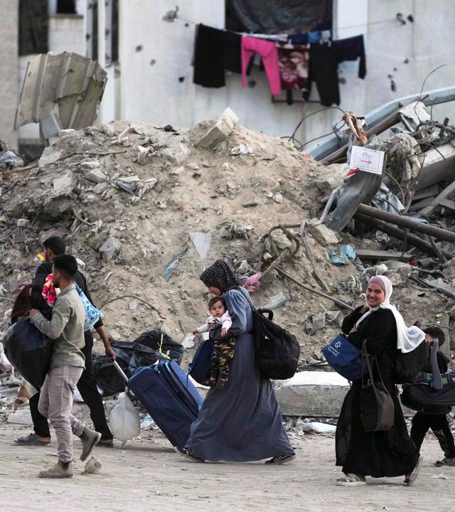 Palästinenser evakuieren, nachdem die israelische Armee eine Evakuierungswarnung für mehrere Schulen und ein Krankenhaus im Stadtteil Rimal in Gaza-Stadt ausgesprochen hat.